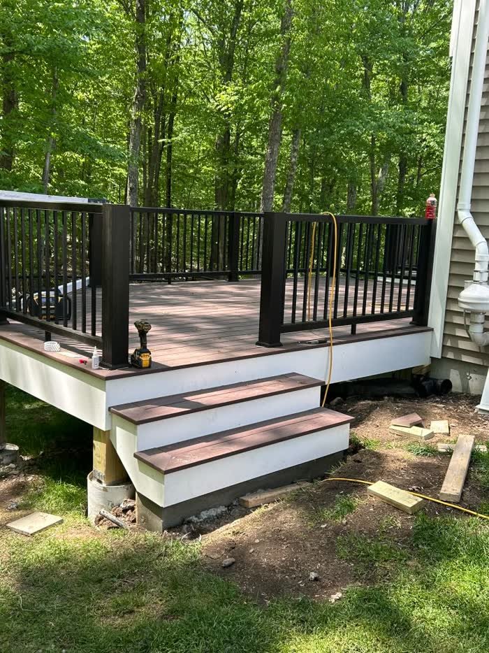 Finished deck with black railing and steps