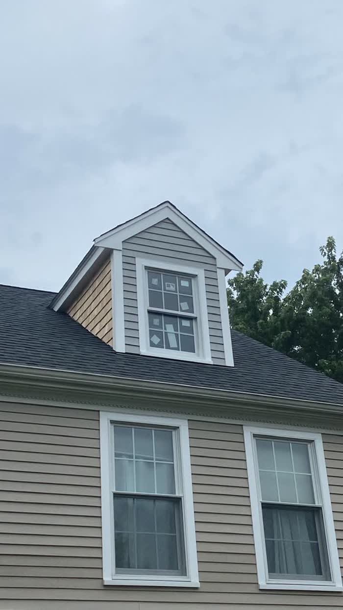 Dormer with gray siding and white trim